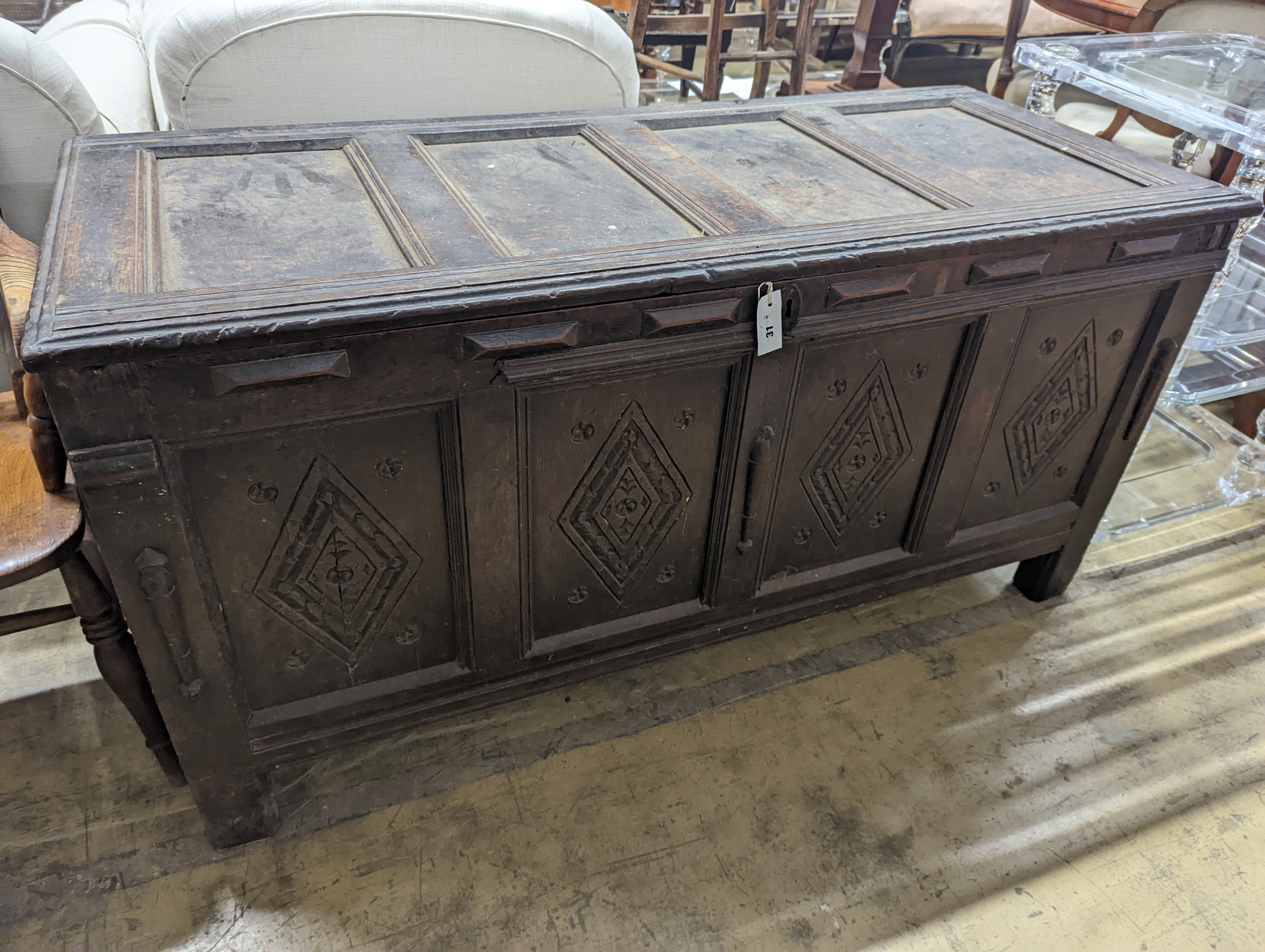 An early 18th century oak coffer, with four panel top and later carved and applied decoration, length 151cm, depth 63cm, height 76cm